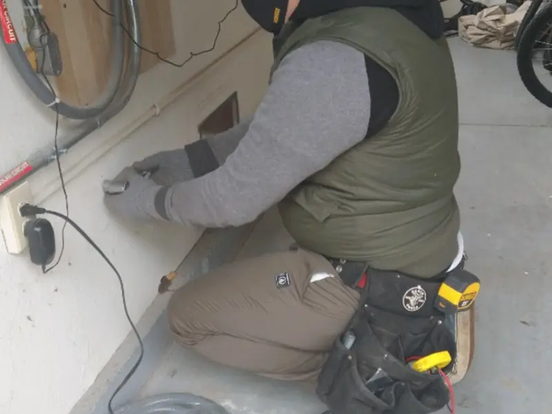 Electrician performing outlet wiring in a Pine Bluff garage